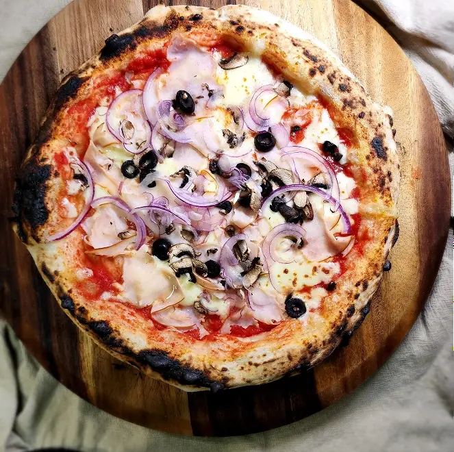 SR Pizza mushroom and onion pizza on a wooden board