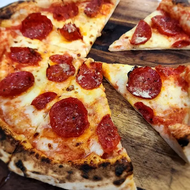 SR Pizza pepperoni pizza served at an event